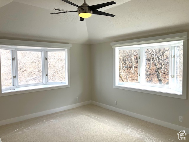 Unfurnished room with a healthy amount of sunlight, ceiling fan, and light carpet