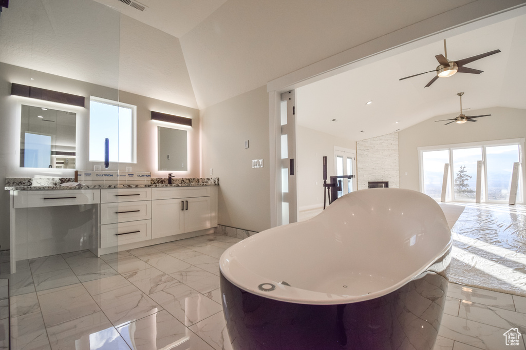 Bathroom featuring tile floors, ceiling fan, a bath to relax in, and vanity with extensive cabinet space