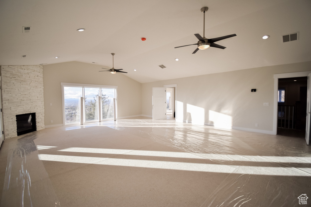 Unfurnished living room featuring a fireplace, ceiling fan, and vaulted ceiling