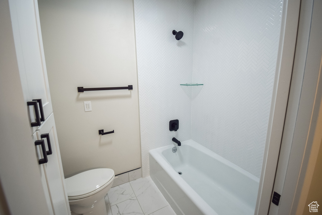 Bathroom with shower / washtub combination, toilet, and tile flooring