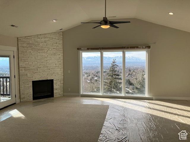 Unfurnished living room with a fireplace, ceiling fan, and lofted ceiling