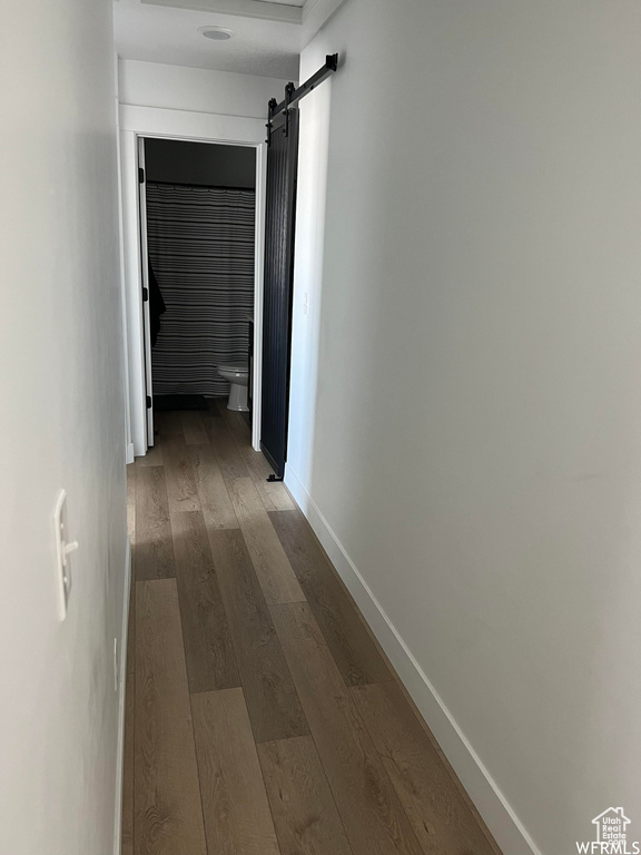 Hallway featuring dark hardwood / wood-style flooring and a barn door