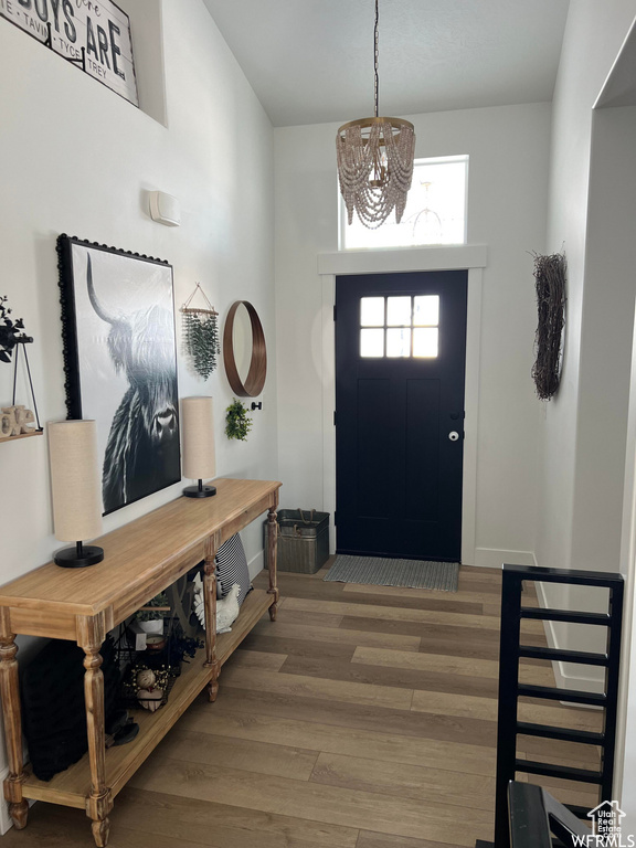 Entryway with dark wood-type flooring and an inviting chandelier