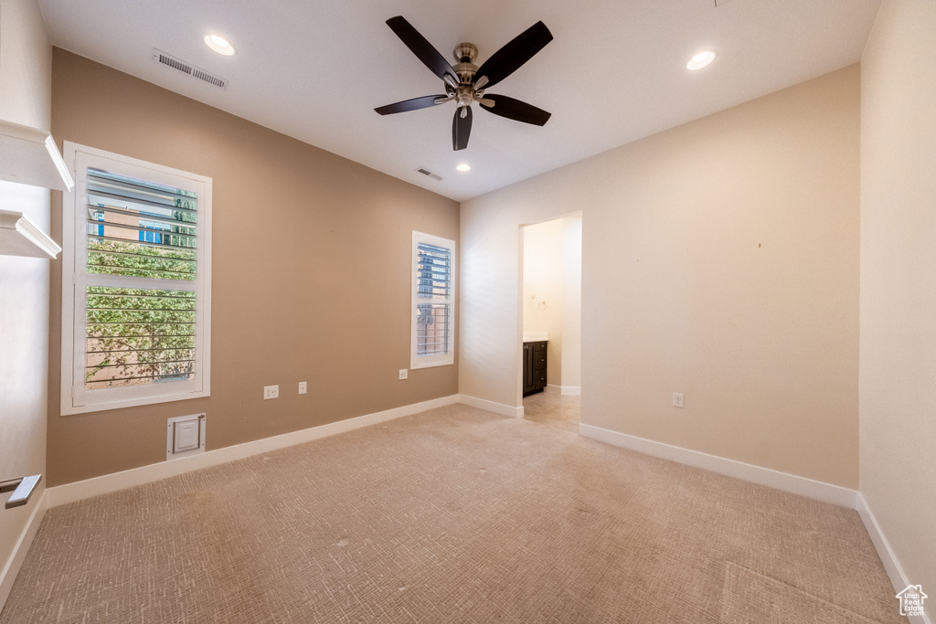Unfurnished room featuring ceiling fan and light carpet