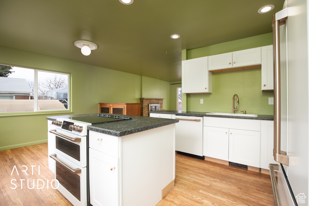 Kitchen with a wealth of natural light, sink, a kitchen island, and high quality appliances