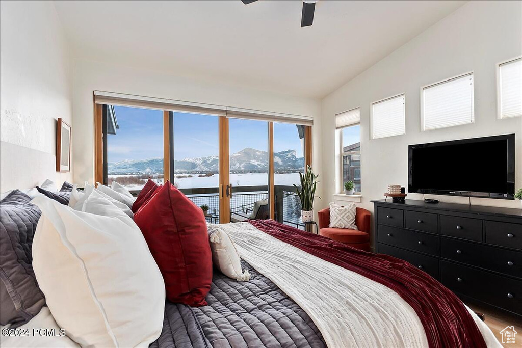 Bedroom with access to outside, a water and mountain view, ceiling fan, and lofted ceiling