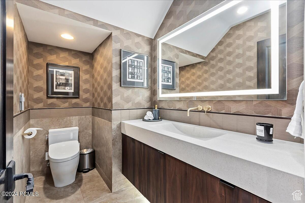 Bathroom with vanity, tile walls, tile flooring, and toilet