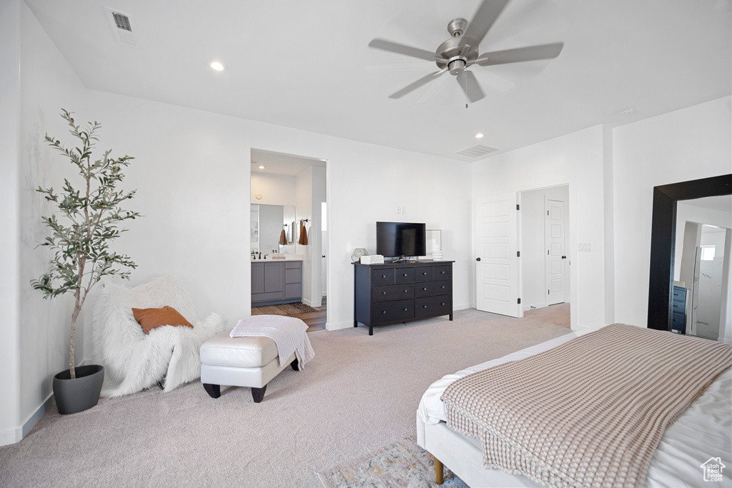 Bedroom featuring ensuite bath, ceiling fan, and light colored carpet
