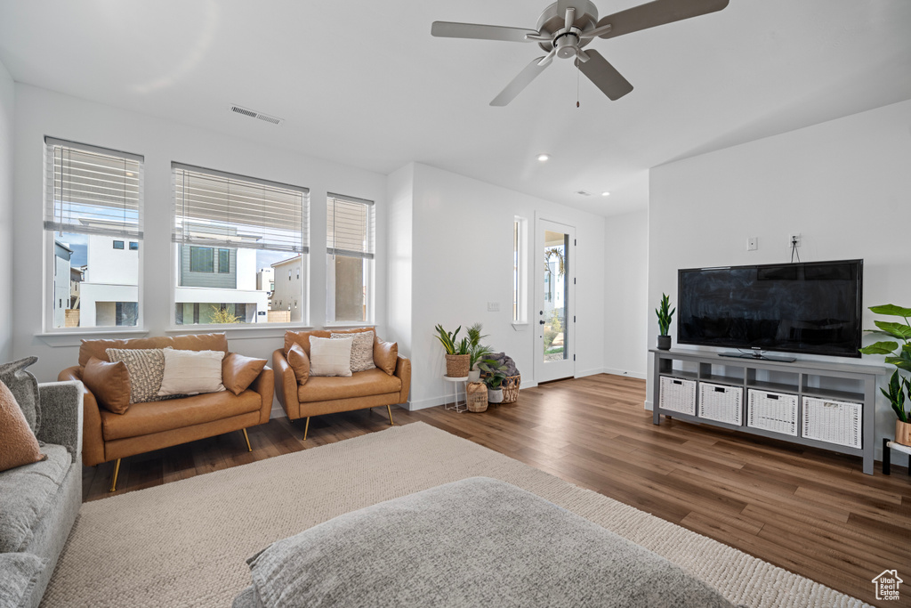 Living room featuring a wealth of natural light, dark hardwood / wood-style floors, and ceiling fan
