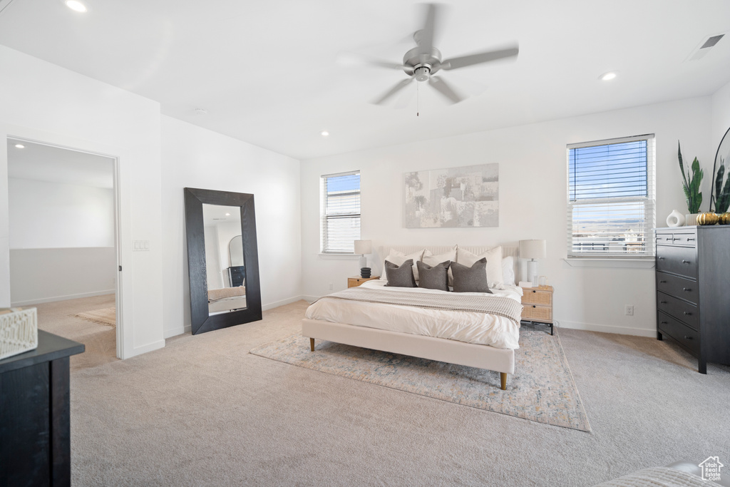 Bedroom with ceiling fan and light colored carpet