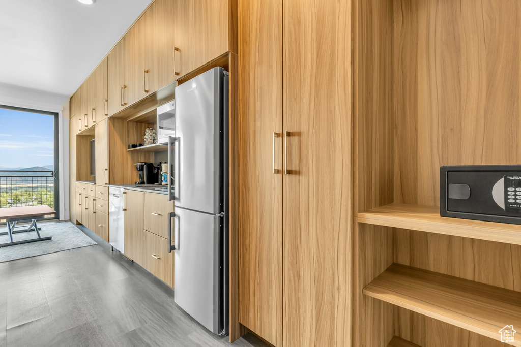 Kitchen featuring light tile flooring, light brown cabinetry, and stainless steel refrigerator