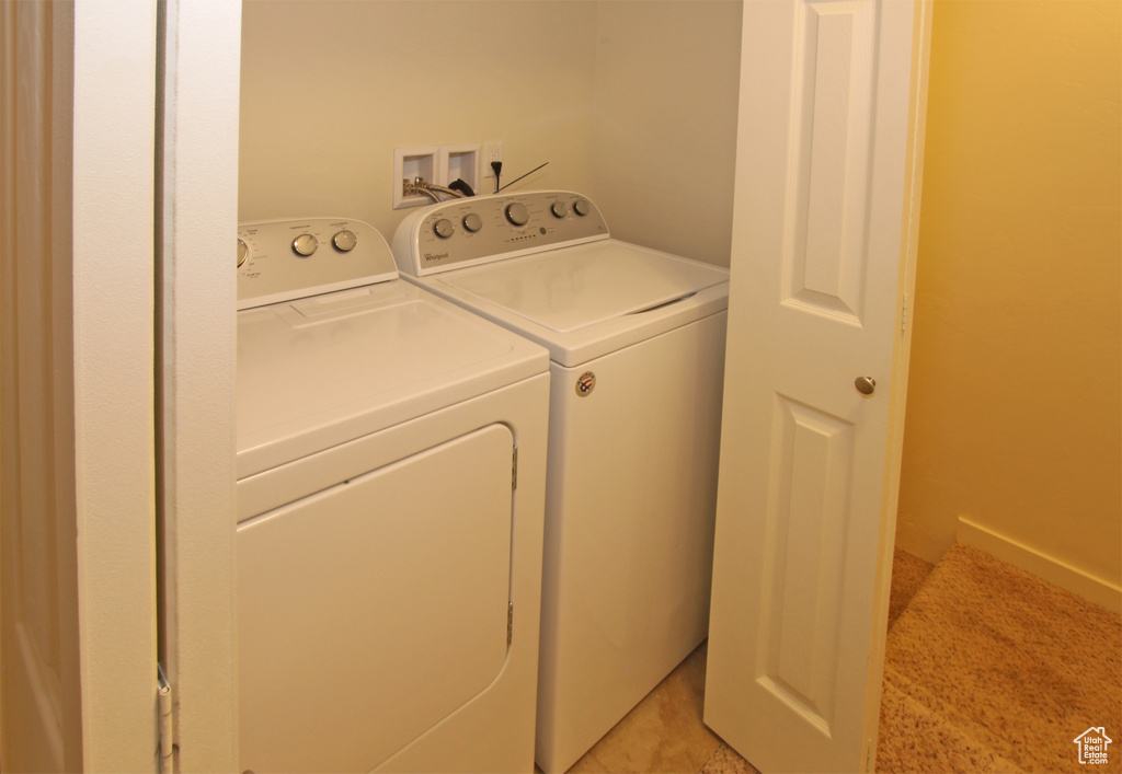 Laundry room featuring washer hookup, washing machine and dryer, and light tile floors