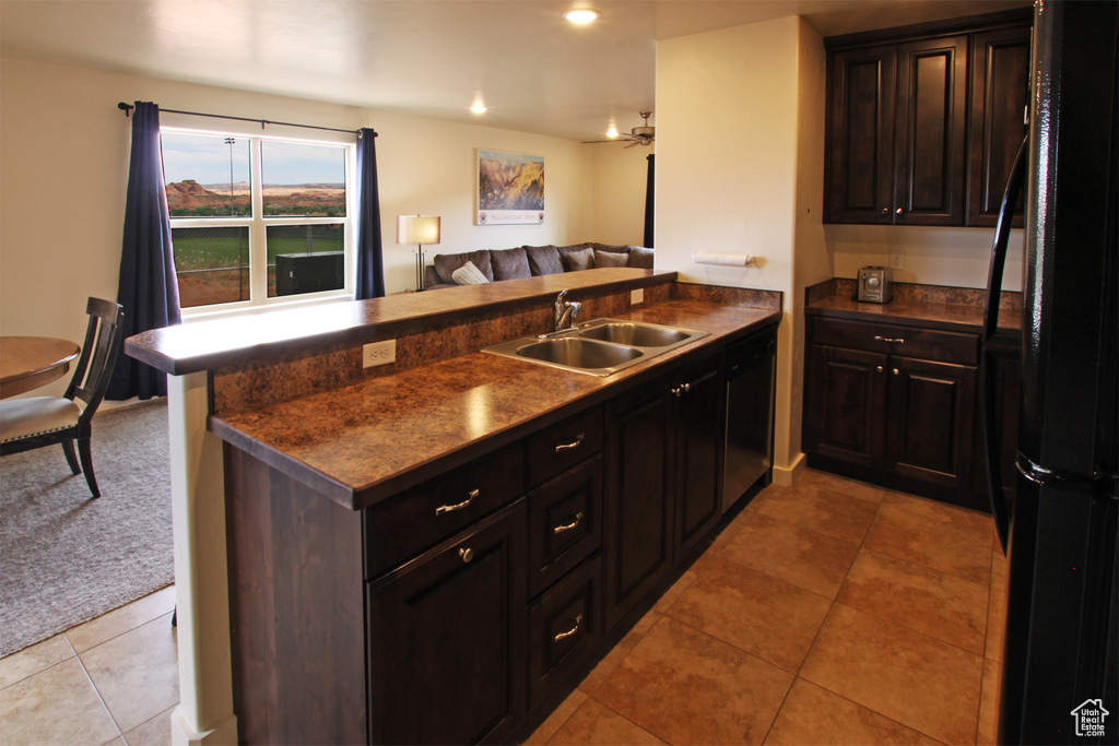 Kitchen with black appliances, ceiling fan, sink, light tile flooring, and kitchen peninsula