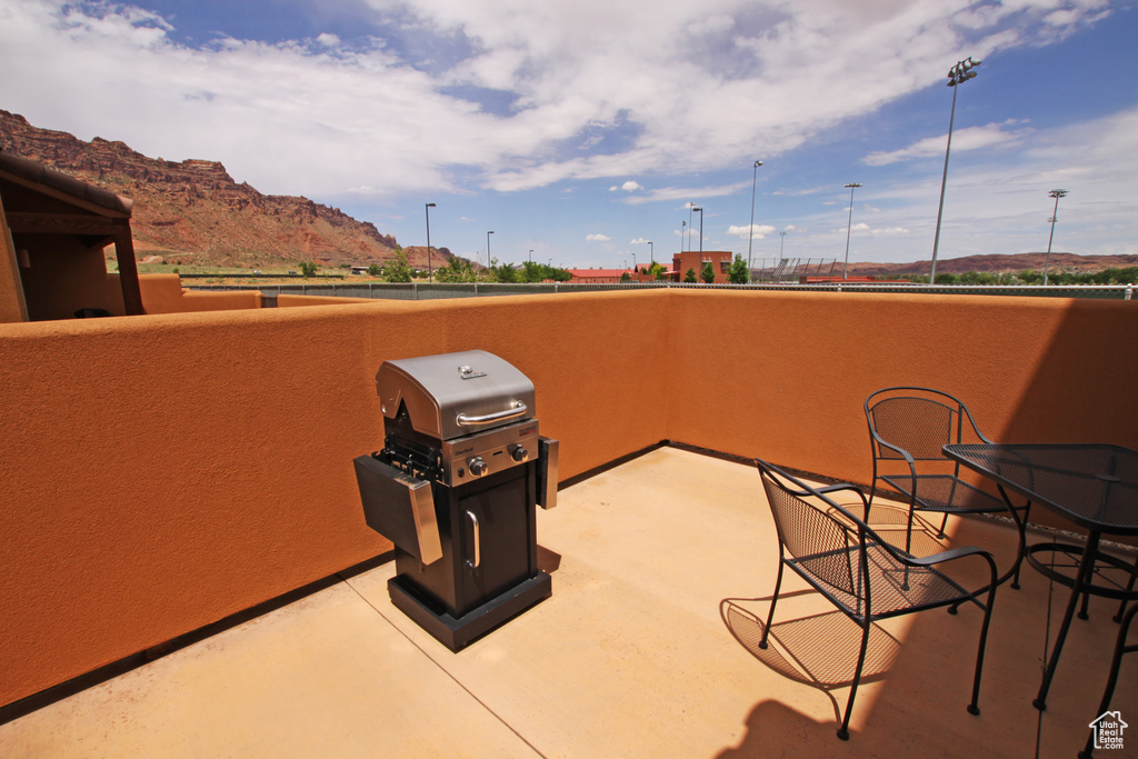 View of patio featuring a mountain view, area for grilling, and a balcony