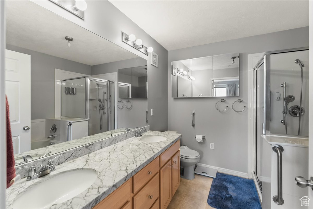 Full bathroom featuring oversized vanity, double sink, toilet, separate shower and tub, and tile floors