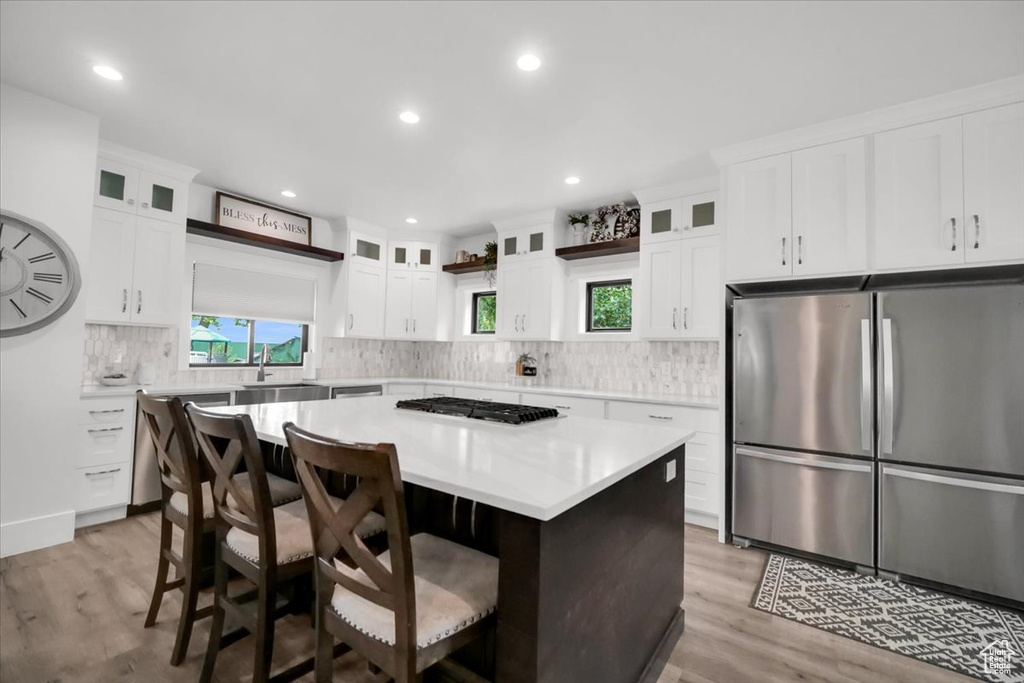 Kitchen with white cabinets, a kitchen island, and stainless steel appliances