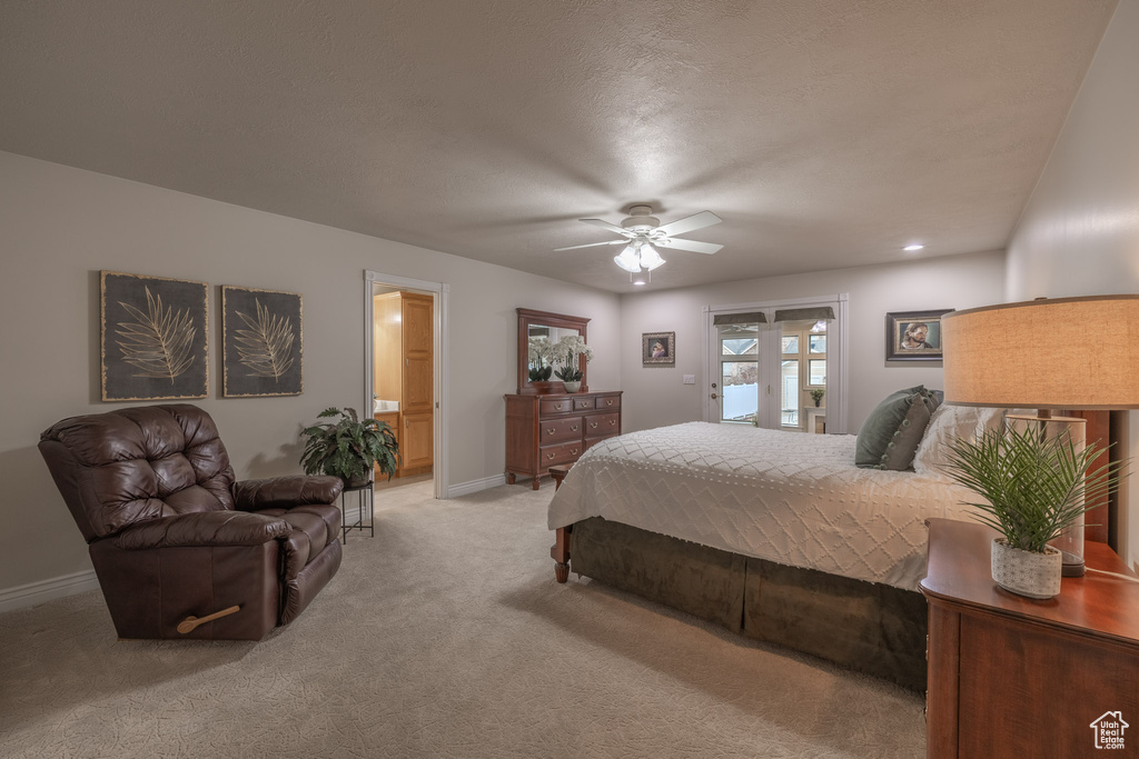 Carpeted bedroom featuring ceiling fan and ensuite bath
