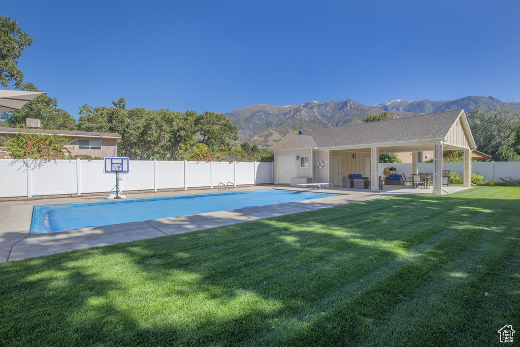 View of swimming pool featuring a mountain view, a patio, and a yard