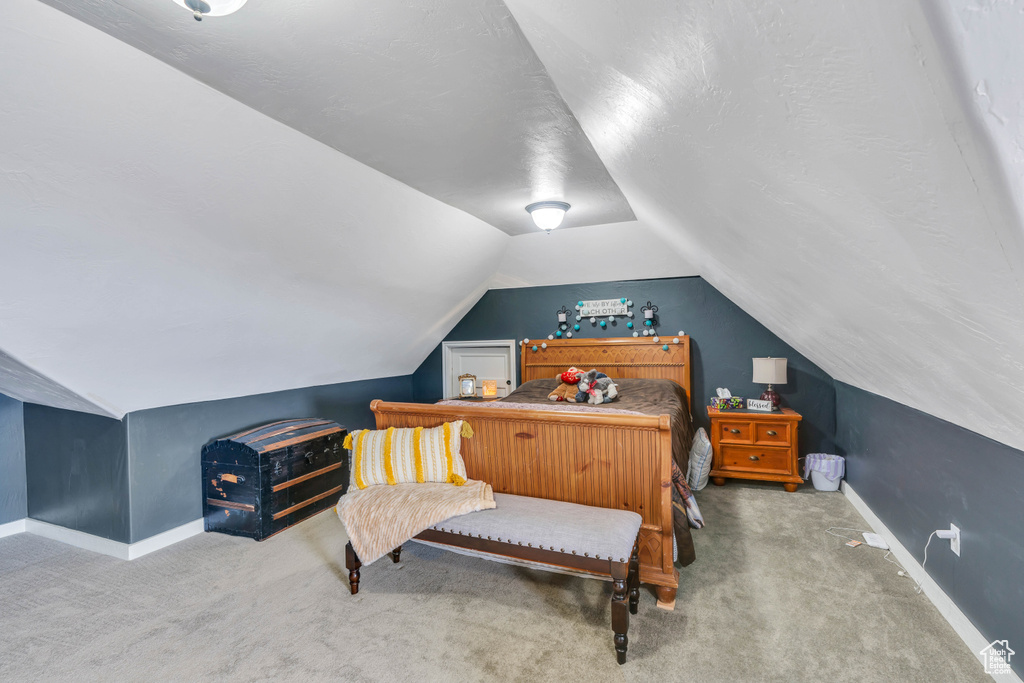 Carpeted bedroom featuring vaulted ceiling