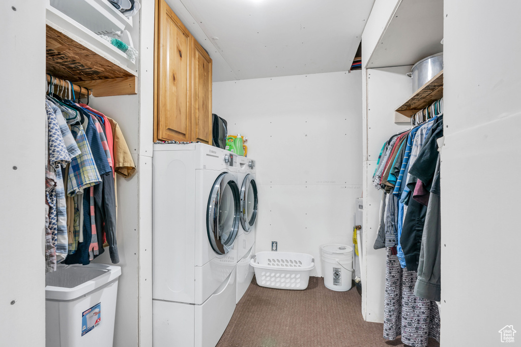 Laundry room with cabinets, washing machine and dryer, and carpet