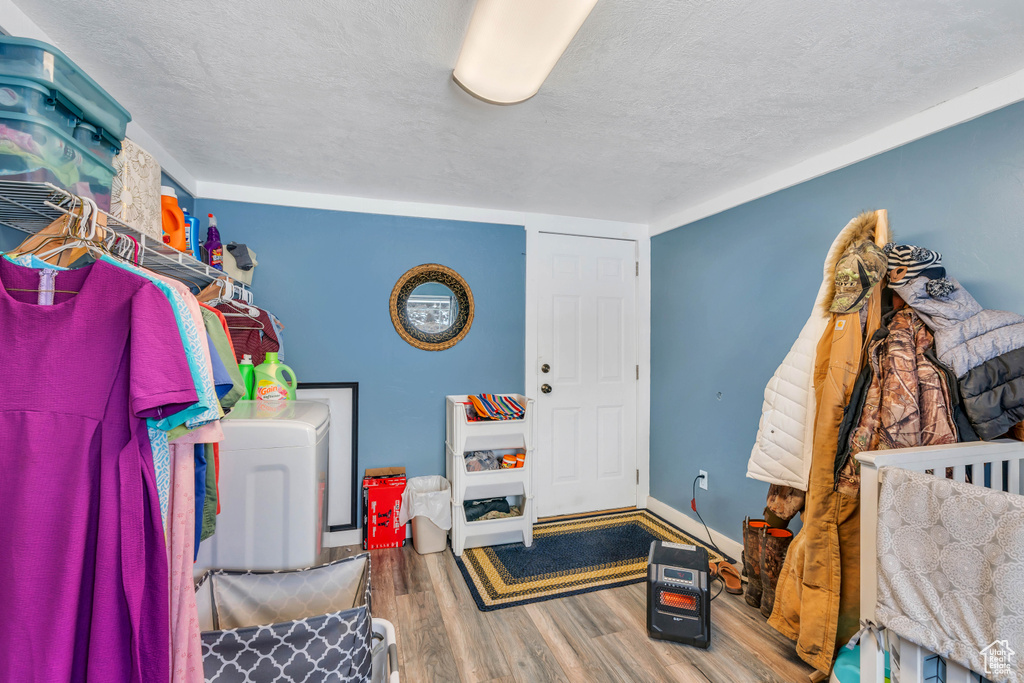 Interior space with washer / clothes dryer, a textured ceiling, and hardwood / wood-style flooring