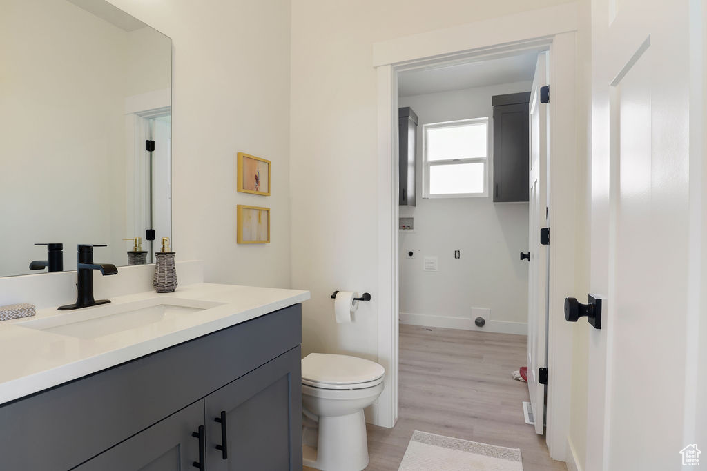 Bathroom featuring hardwood / wood-style floors, vanity, and toilet