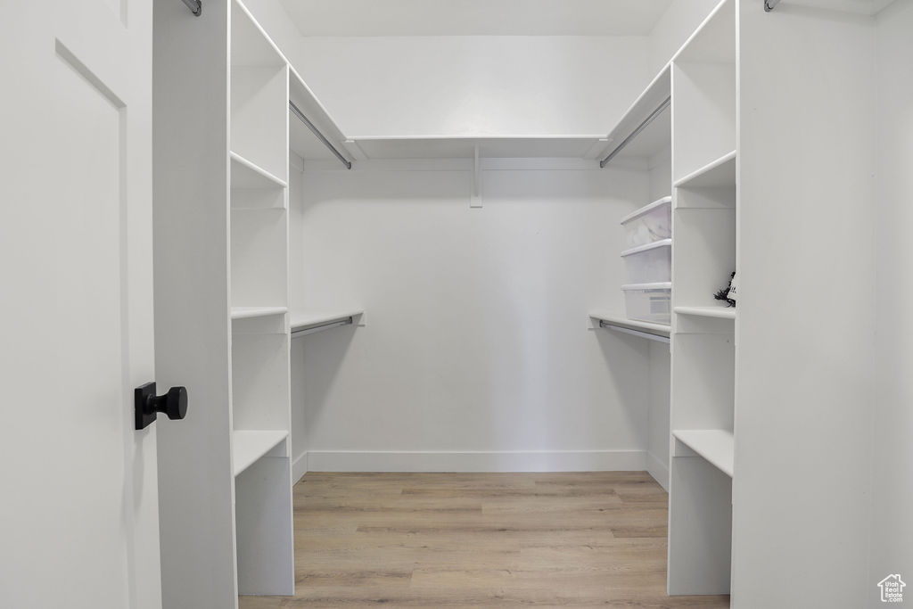 Spacious closet featuring light hardwood / wood-style floors