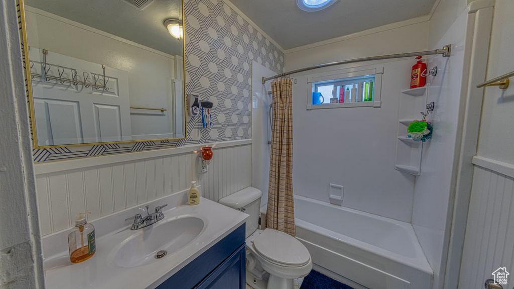 Full bathroom featuring vanity with extensive cabinet space, shower / bath combination with curtain, and toilet
