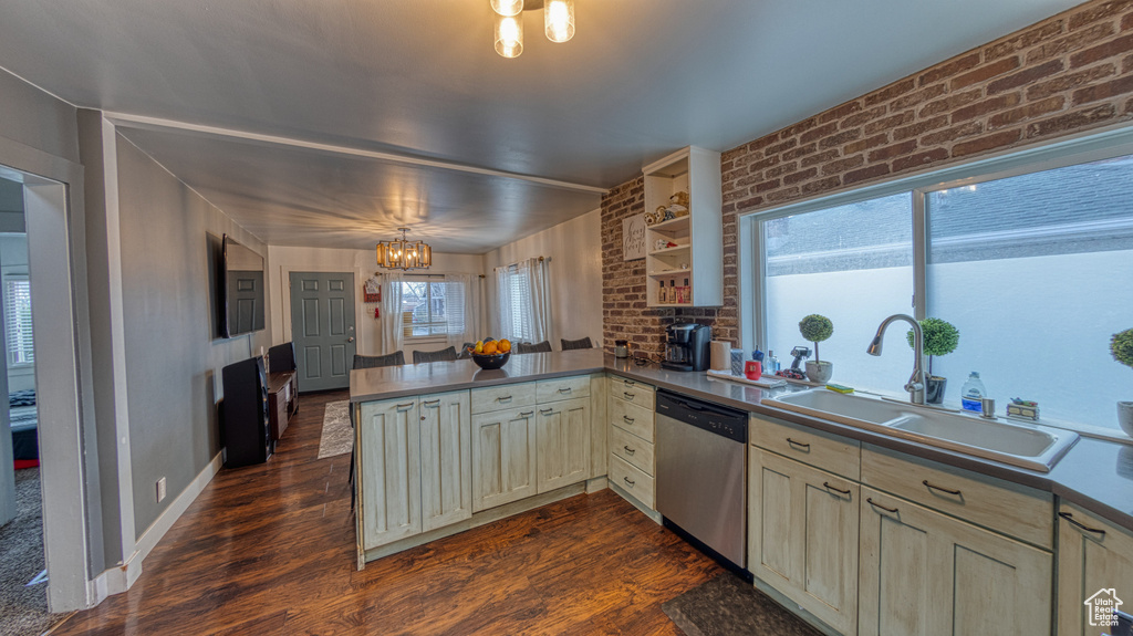Kitchen with dishwasher, dark wood-type flooring, an inviting chandelier, sink, and kitchen peninsula