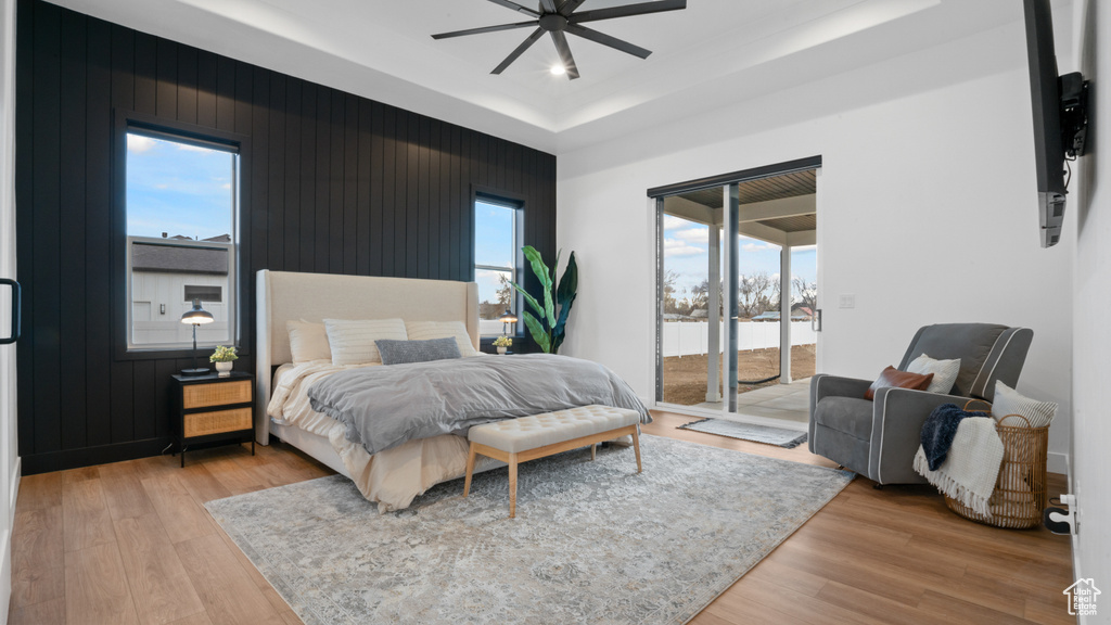 Bedroom with light hardwood / wood-style floors, ceiling fan, and access to outside