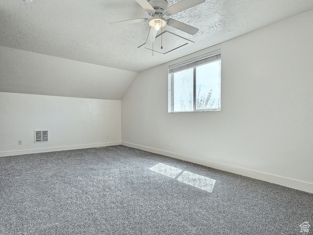 Bonus room with carpet flooring, ceiling fan, a textured ceiling, and lofted ceiling