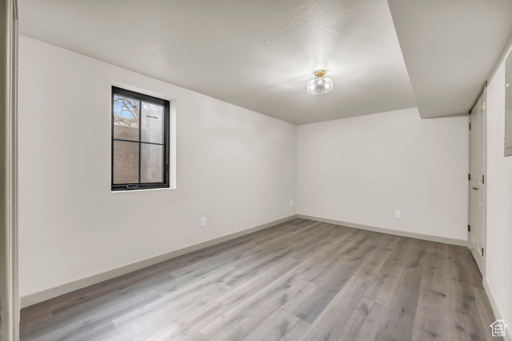 Unfurnished room featuring light hardwood / wood-style flooring and a textured ceiling