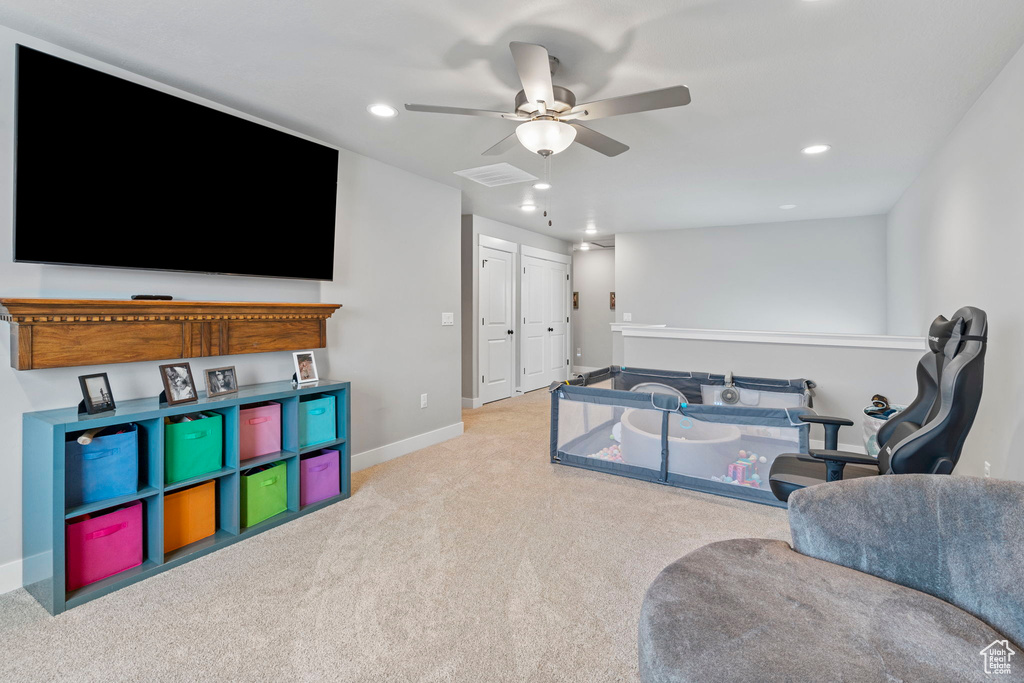 Rec room featuring ceiling fan and light colored carpet