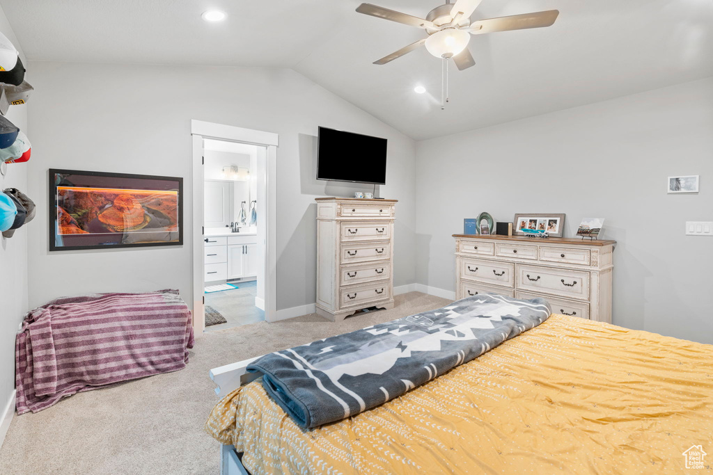Bedroom featuring ensuite bathroom, ceiling fan, light colored carpet, and lofted ceiling