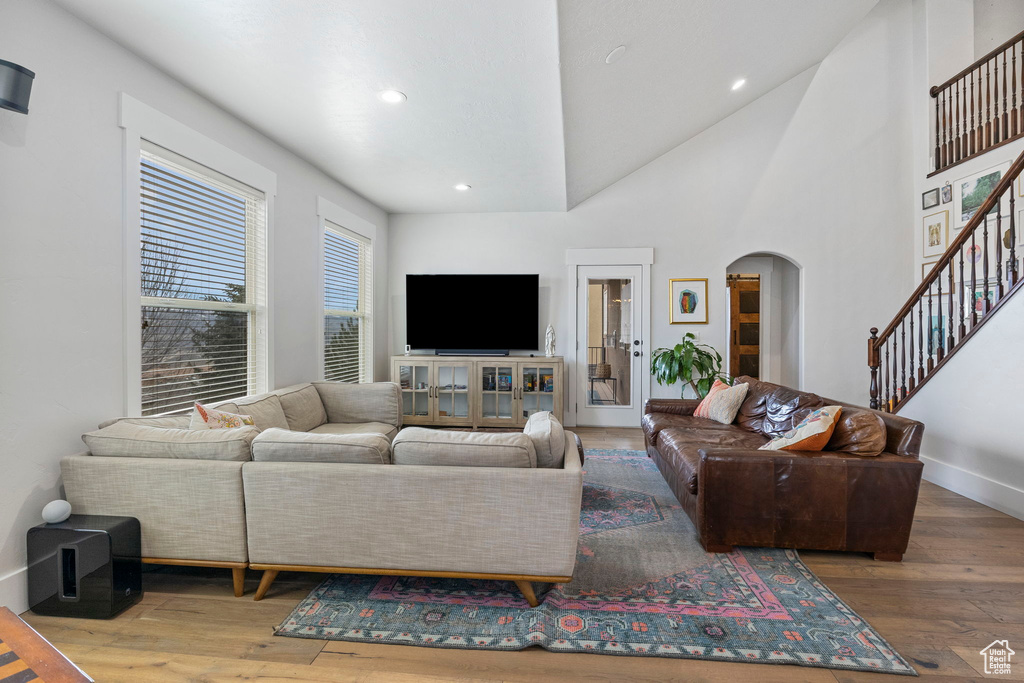 Living room featuring dark hardwood / wood-style floors, a healthy amount of sunlight, and high vaulted ceiling