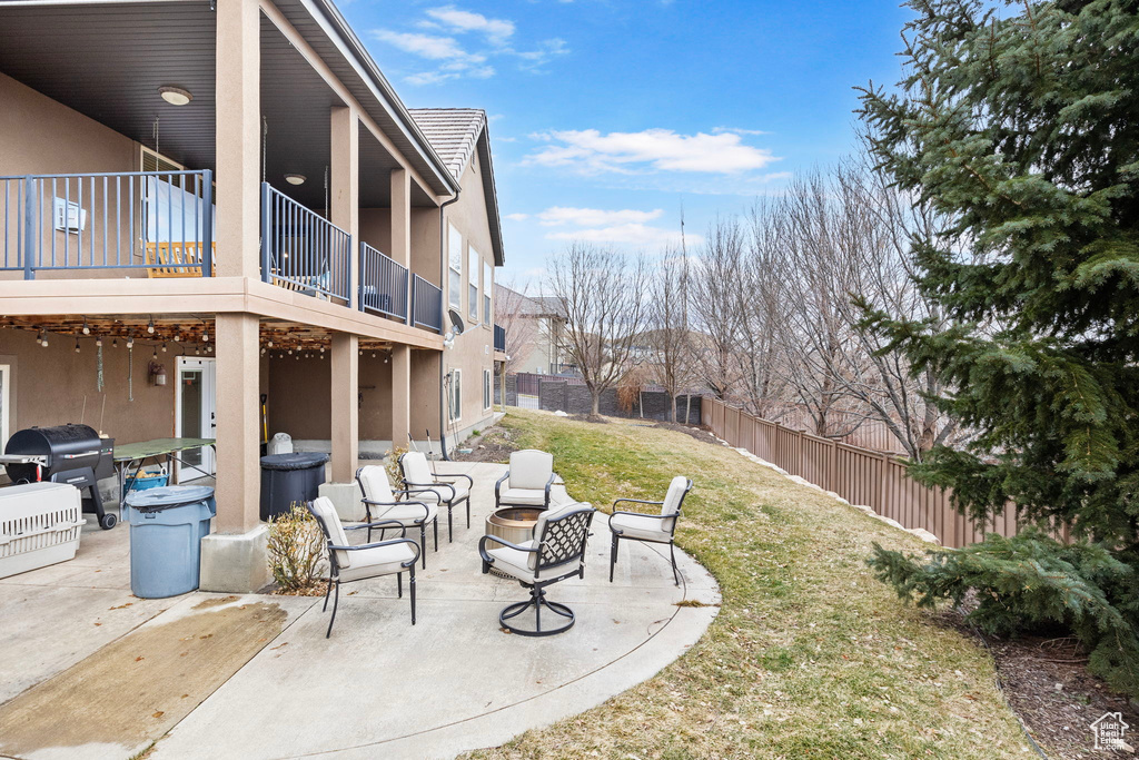 View of yard featuring a patio, an outdoor fire pit, and a balcony