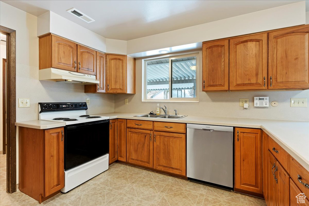 Kitchen featuring white electric range oven, light tile floors, dishwasher, and sink
