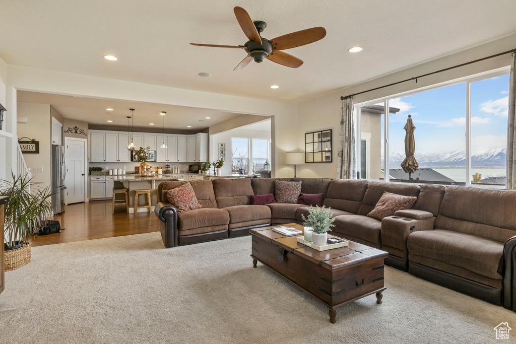 Carpeted living room featuring a wealth of natural light and ceiling fan