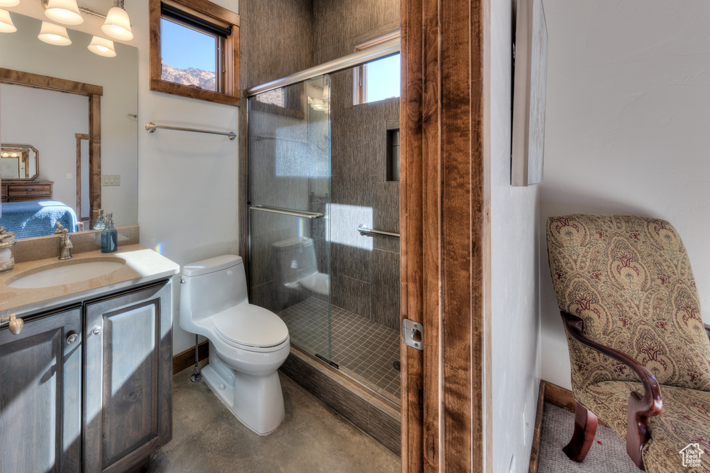Bathroom with a shower with door, large vanity, and toilet
