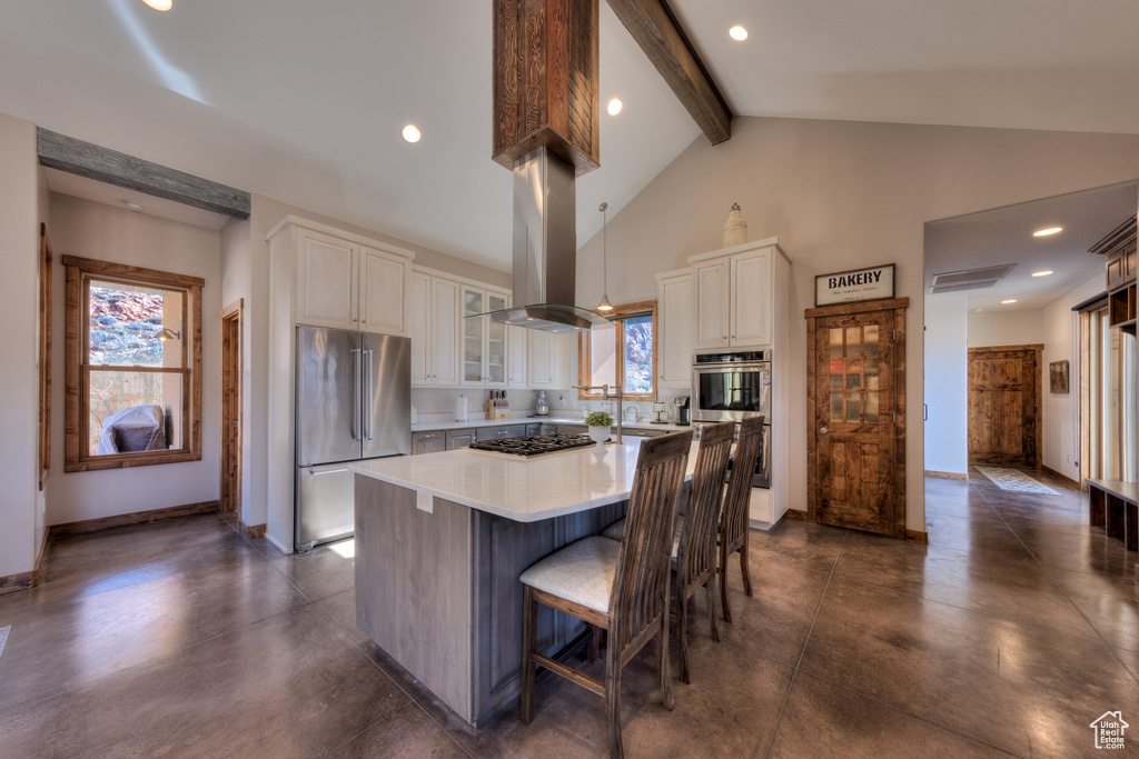 Kitchen with a kitchen bar, a center island, island exhaust hood, beamed ceiling, and stainless steel appliances