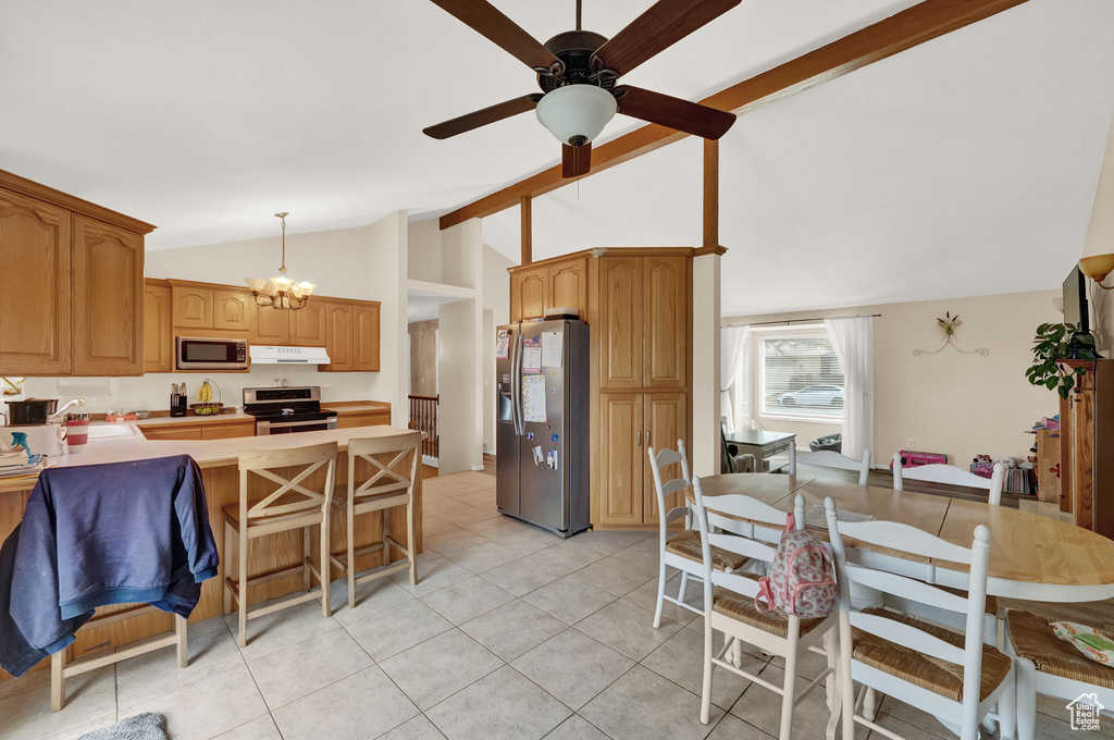 Kitchen featuring ceiling fan with notable chandelier, hanging light fixtures, appliances with stainless steel finishes, sink, and light tile floors