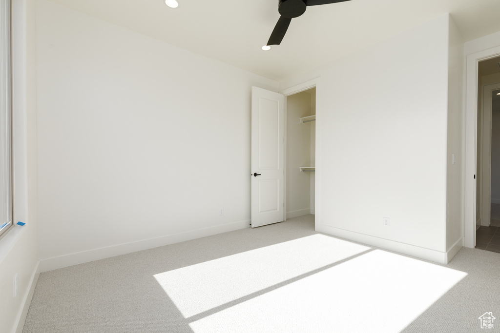 Interior space with light carpet and ceiling fan