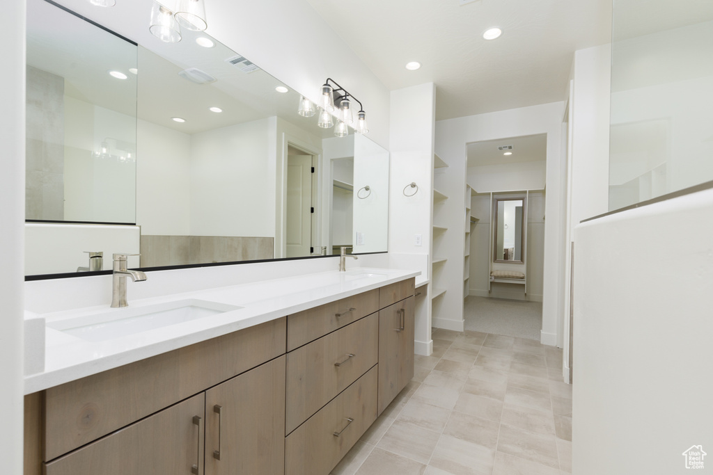 Bathroom featuring tile patterned floors and dual bowl vanity