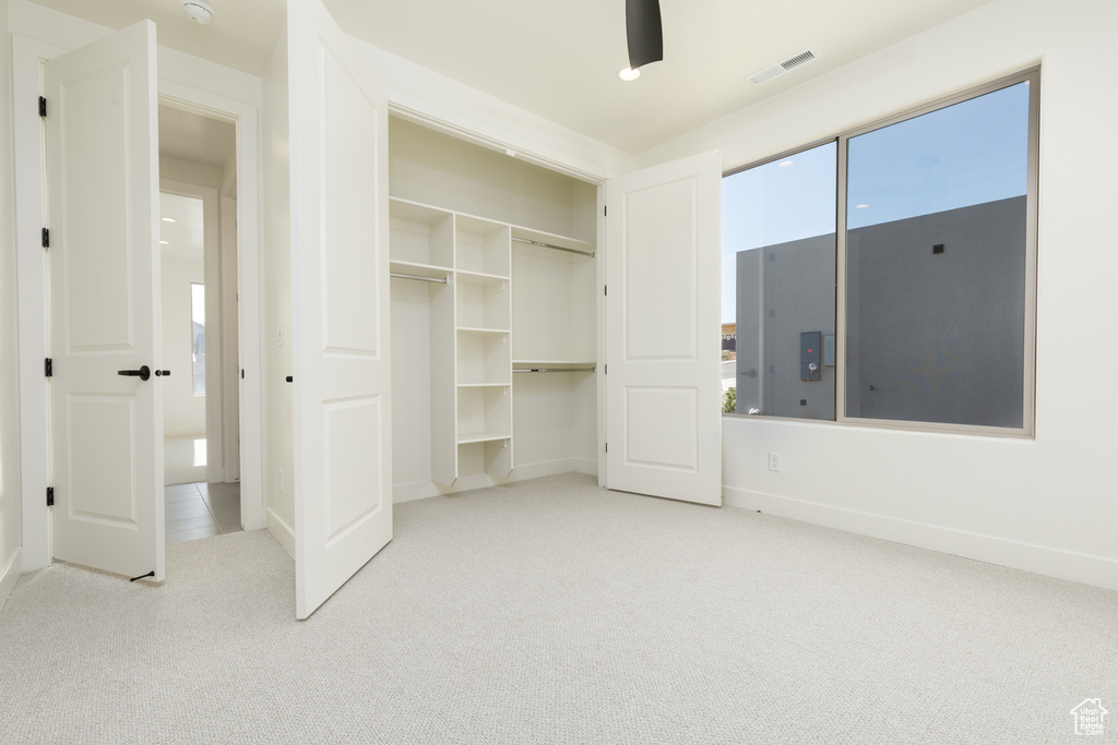 Unfurnished bedroom with light carpet and a closet