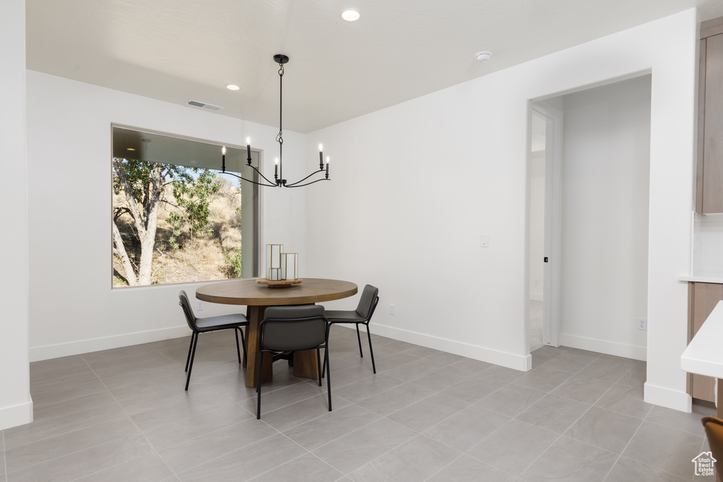 Tiled dining room featuring a notable chandelier