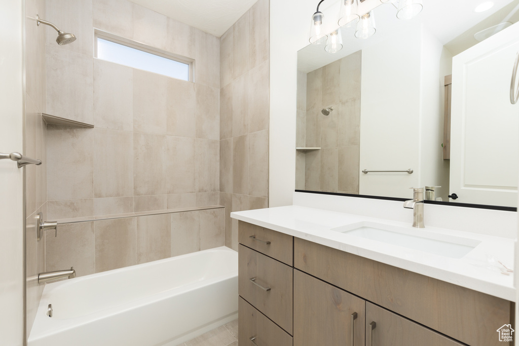 Bathroom featuring tiled shower / bath combo and vanity