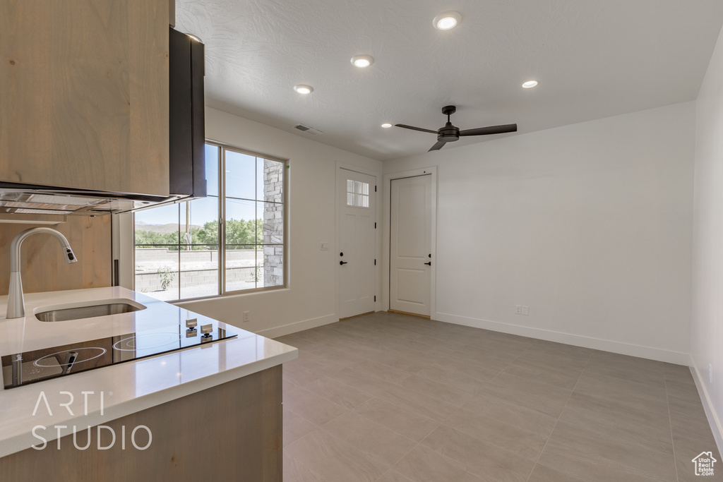 Kitchen with light tile patterned flooring, sink, and ceiling fan