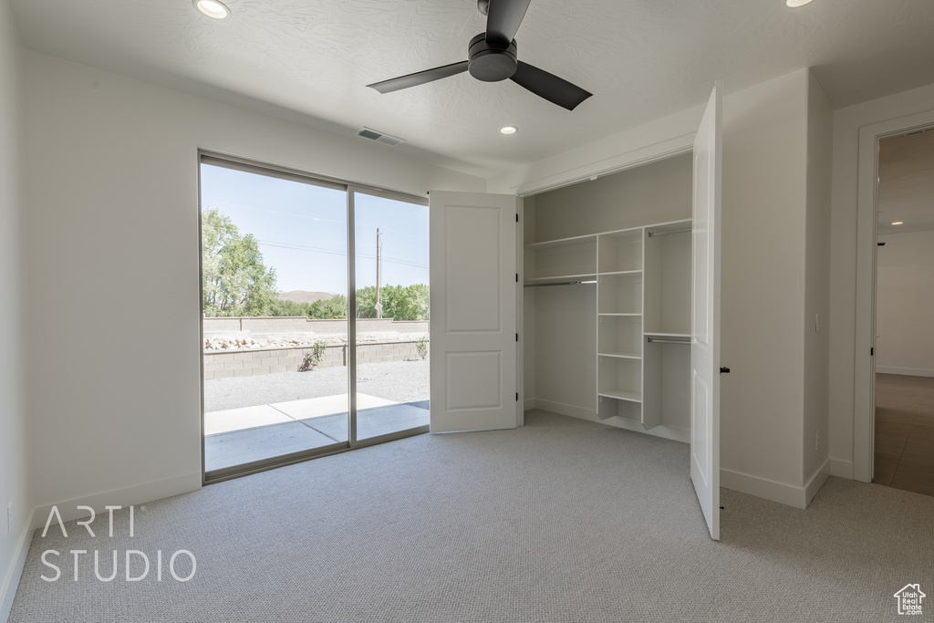 Unfurnished bedroom featuring ceiling fan, access to exterior, and light colored carpet