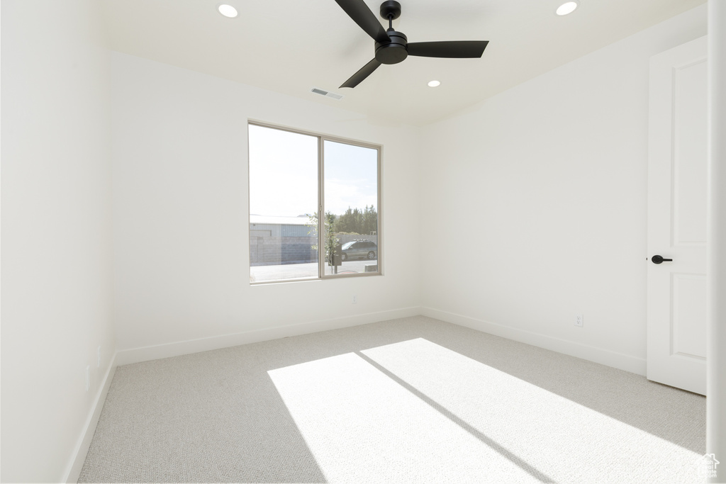 Carpeted spare room with ceiling fan