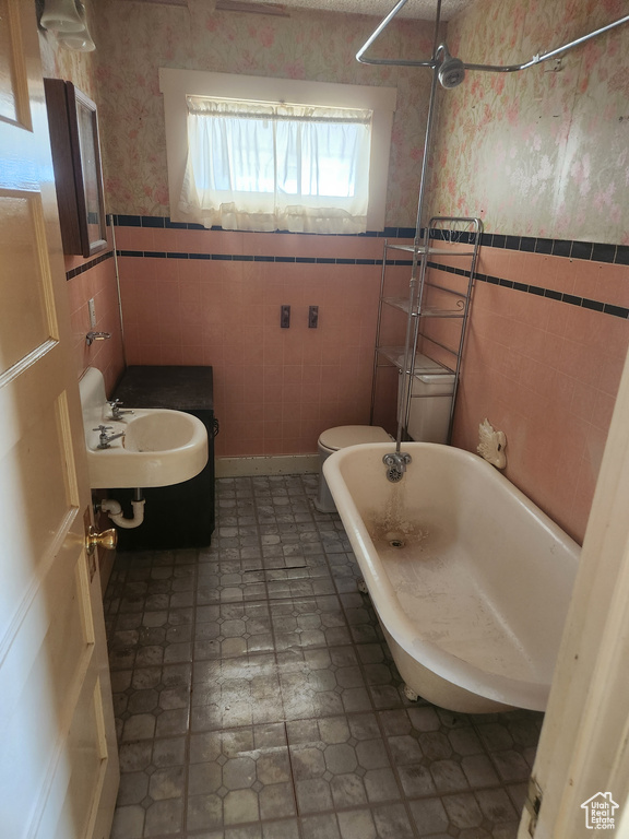 Bathroom featuring sink, tile walls, tile flooring, and toilet